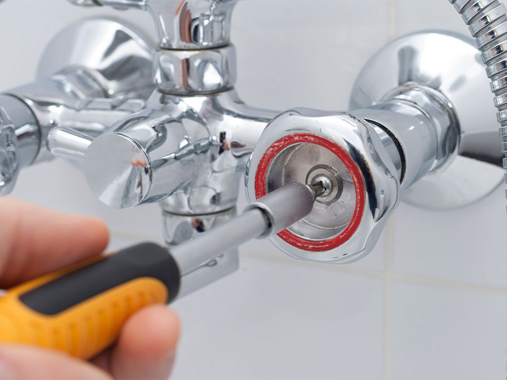 Handyman Yorkshire loosening a shower tap head to change a ceramic cartridge